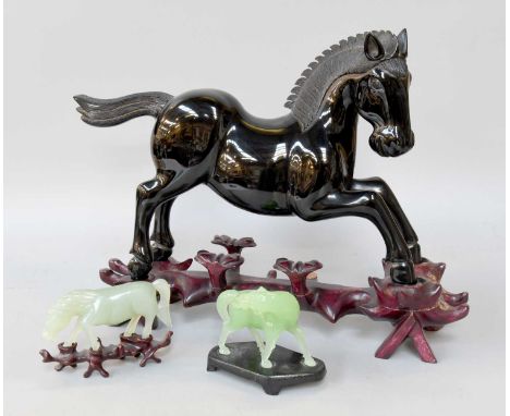 A Chinese Cherry Amber Effect Model of a Horse in Case; together with two celadon jade horses (3)