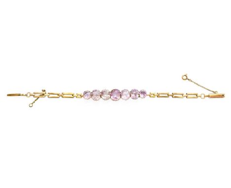 An Amethyst Bracelet, seven graduated cushion cut amethysts in yellow claw settings, to a brick link back chain, length 17.3c