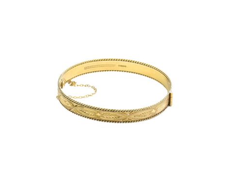 A 9 Carat Gold Hinged Bangle, of textured and engraved form, inner measurements 5.8cm by 5.3cmGross weight 14.7 grams.