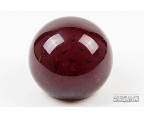 A 1960s Whitefriars ruby glass paperweight with uniform bubble inclusions, pattern 9308, unmarked, 7.5cm diameter approx.