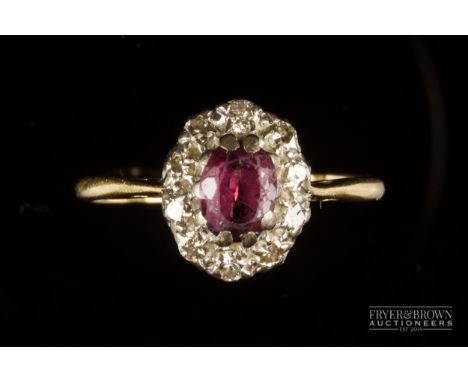 A ruby and diamond cluster ring mounted in 18ct yellow and white gold