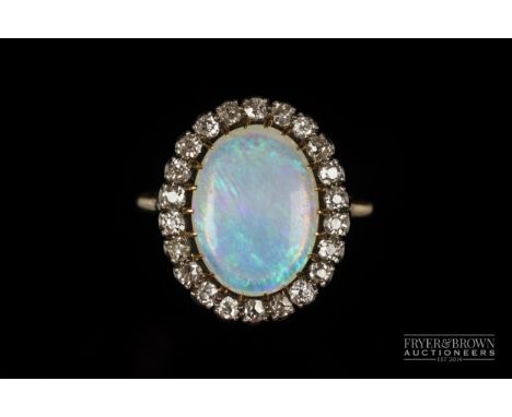 An Edwardian opal and diamond dress ring, the oval opal within a 22 stone old brilliant cut diamond surround