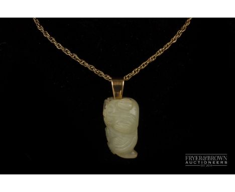 A pale celadon coloured jade kylin pendant, on a fancy link 9ct gold chain 