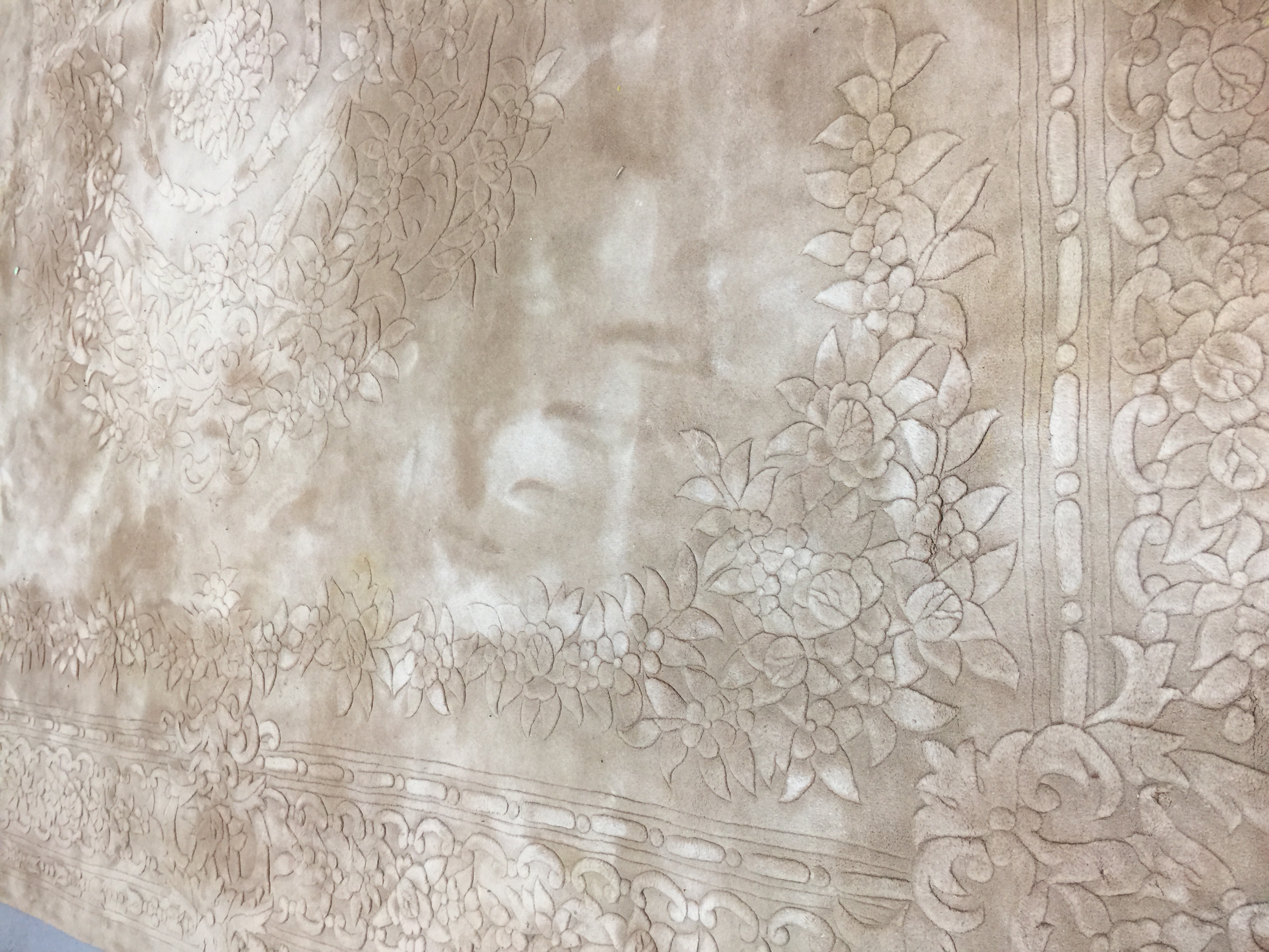 LARGE WASHED CHINESE EMBOSSED RUG. With floral designs and tasselled