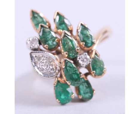 A yellow metal dress ring, stamped 585, set with emeralds and diamonds, size K, 6.8g