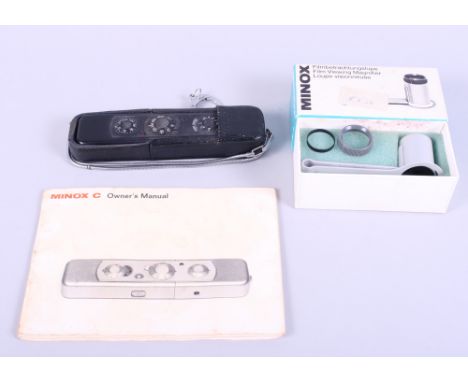 A Minox "C" spy camera, in black, with a film viewing magnifier