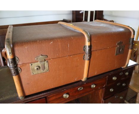 A brown canvas and wooden travelling trunk, 32" wide x 12 1/2" high