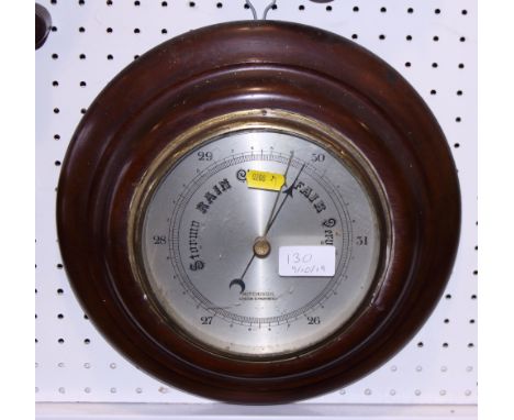 A circular mahogany cased barometer with silvered dial and a brass shop bell