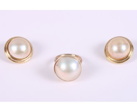 A 9ct gold ring set pearl, ring size L, and a similar pair of yellow metal mounted pearl earrings, stamped 14K