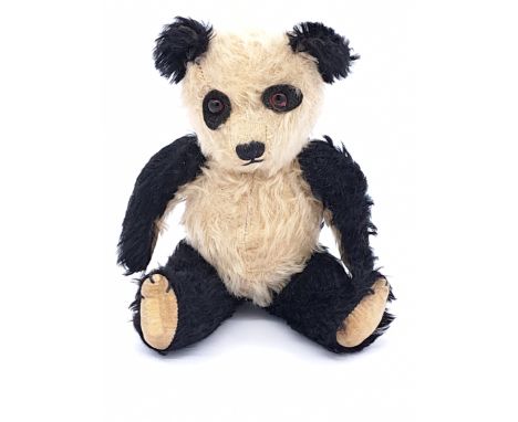 Chiltern vintage panda bear, 1950s, black and white mohair, amber and black glass eyes- seated on black felt, black verticall