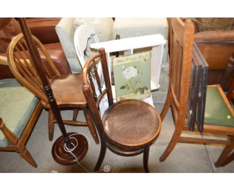 A small white painted wall shelf; a small metal sign and a table lamp base 