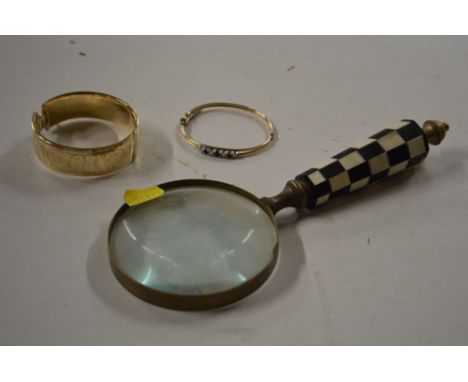 A yellow metal snap bangle; another set white and blue stones; and a large magnifying glass