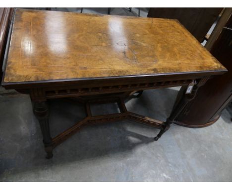 A Victorian bur walnut folding games tablesThe rectangular folding top inlaid with stringing above a spindled gallery frieze 