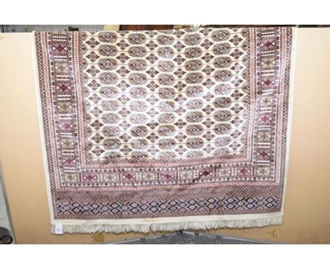 A Bokhara carpet with tasseled borders on beige ground. (230 x 160cm) 