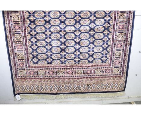 A Bokhara carpet with tasseled borders and blue ground. (230 x 160cm) 