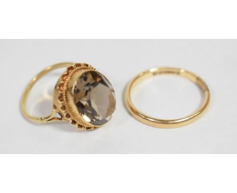 A 9 carat gold band ring, finger size T; a Victorian smokey quartz ring in a yellow metal mount, finger size O1/2; a Victoria