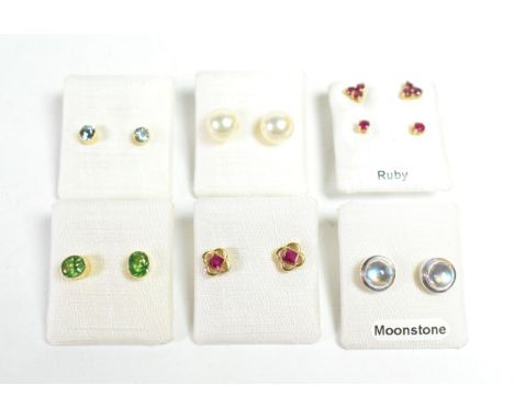 A pair of 9 carat white gold moonstone stud earrings; three pairs of 9 carat gold ruby stud earrings; a pair of cultured pear