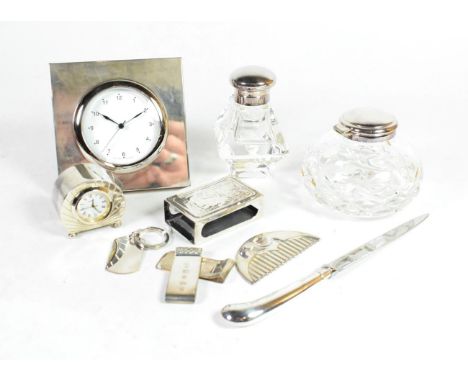 Mixed silver items comprising: two silver mounted bedside timepieces, the largest timepiece 10cm square; two inkwells; a matc