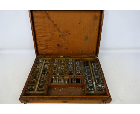 An optometrist's vintage test lenses set in fitted wooden case. [W]