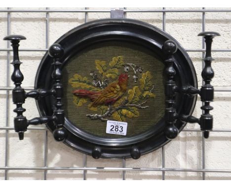 Victorian ebonised oval framed beadwork panel with hinged hanging brackets and hanging pegs to the lower part of the frame, f