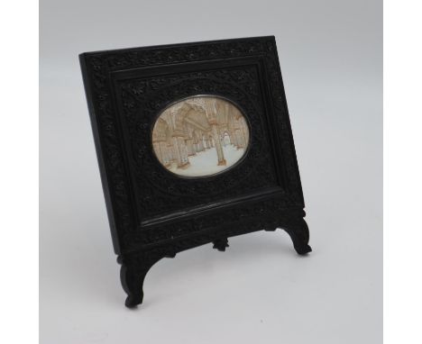 A large Middle-Eastern painted miniature, of an architectural interior, unsigned, 125 x 80 mm, set within a heavily-carved eb