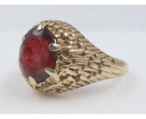 9ct garnet set ring with high-profile textured setting, size N/O, 5.0g. UK P&amp;P Group 0 (£6+VAT for the first lot and £1+V