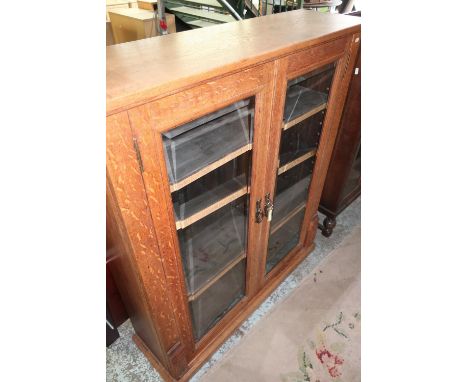 Edwardian light oak bookcase enclosed by two bevel edged glazed cupboard doors (103cm x 30cm x 119cm) 
