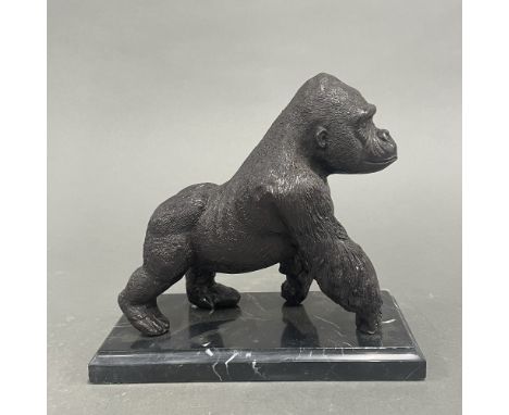 A cast bronze figure of a gorilla on a grey marble base. H. 18cm.