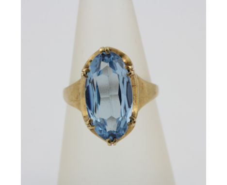 A 9ct yellow gold ring set with a large oval cut blue topaz, stone L. 1.5cm.