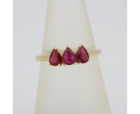 A hallmarked 9ct yellow gold ring set with pear cut rubies, (O).