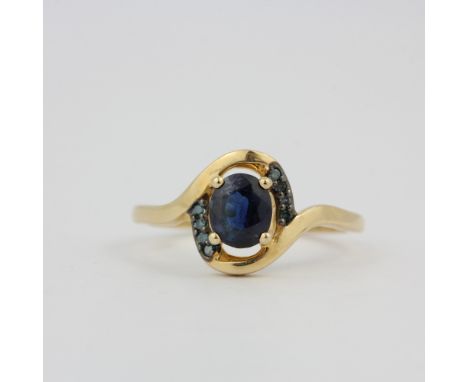 A hallmarked 9ct yellow gold ring set with an oval cut Nigerian sapphire and blue diamonds, (O).