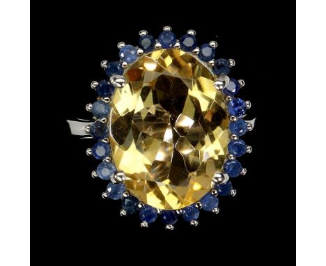 A 925 silver ring set with a large oval cut citrine surrounded by sapphires, (O.5).