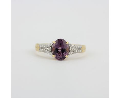 A hallmarked 14ct yellow gold ring set with an oval cut purple tourmaline and diamonds, (O).
