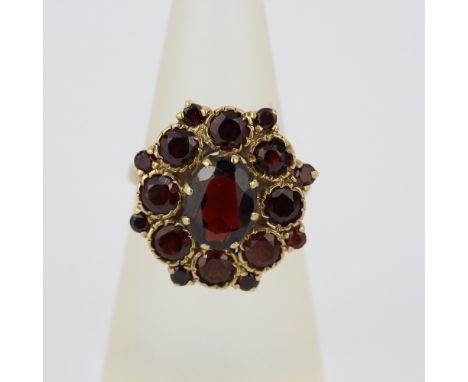 A hallmarked 9ct yellow gold garnet set cluster ring, (M).
