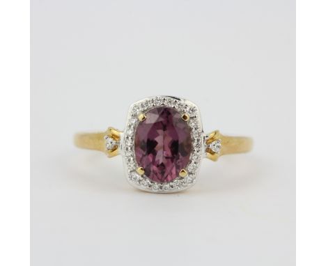 A 14ct yellow gold ring set with an oval cut tourmaline surrounded by diamonds, (O).