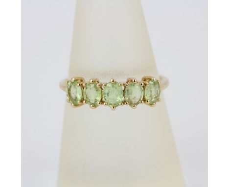 A hallmarked 10ct yellow gold ring set with oval cut peridot, (O).