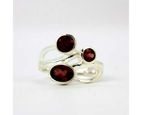 A 925 silver ring set with oval and round cut garnets.