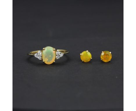 A 10ct yellow gold ring set with an oval cut opal and white topaz, (O), together with a pair of 10ct gold opal solitaire stud