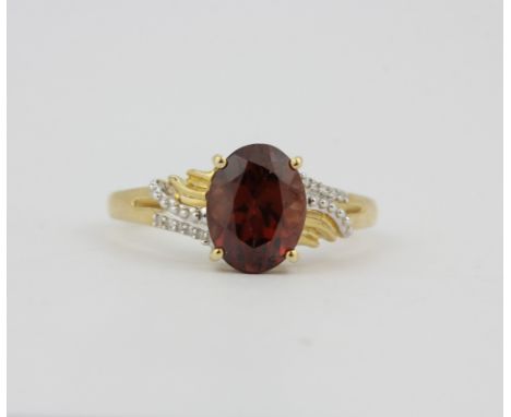 A hallmarked 9ct yellow gold ring set with an oval cut red tourmaline and diamonds, (O).