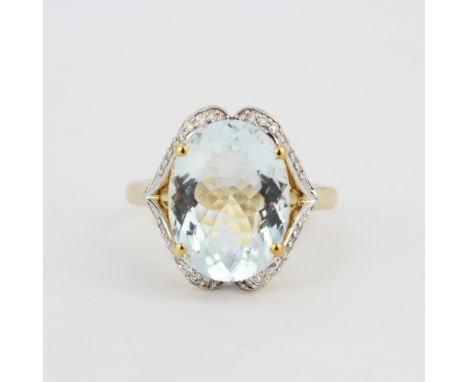 A hallmarked 14ct yellow gold ring set with a large oval cut aquamarine, L. 1.4cm, and diamonds, (O).