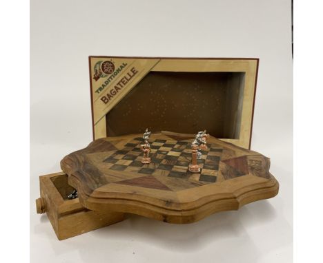 An inlaid wooden chess board and chess set and a boxed bagatelle, chess board Dia. 32cm.