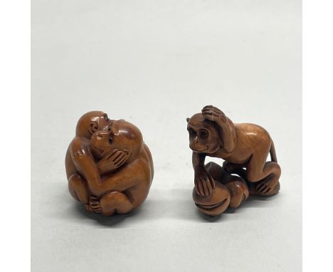 A Chinese carved fruitwood netsuke of a monkey on a branch, together with a further netsuke of two monkeys embracing, signed 