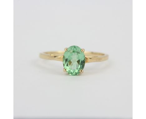 A hallmarked 9ct yellow gold (marked 10K) solitaire ring set with an oval cut peridot, (O).