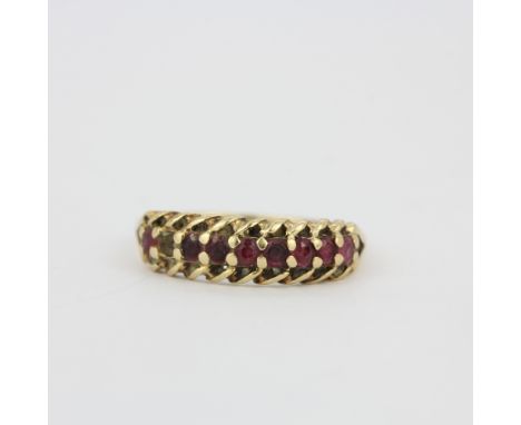 A hallmarked 9ct yellow gold ring set with round cut rubies, (O). One ruby missing. Gross weight approx. 2.2gr.&nbsp;