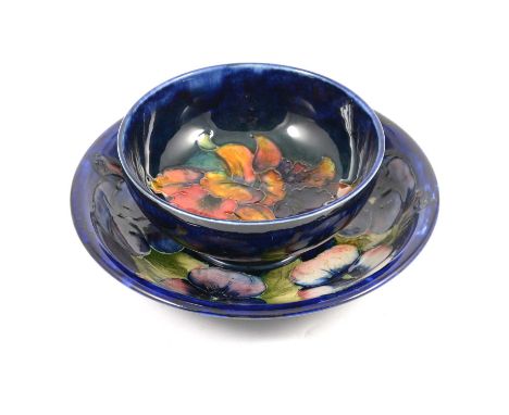 William Moorcroft for Moorcroft Pottery, a 'Pansy' shallow dish, circa 1925, 19cm diam; and an 'Orchid' bowl, 13cm diam, stam