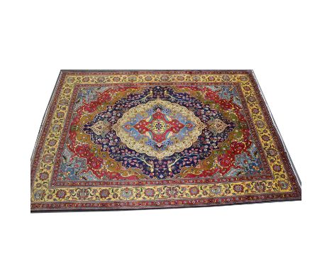 Large Tabriz carpet, large central multi-coloured medallion against a burgundy field with sky blue spandrels, palmette border