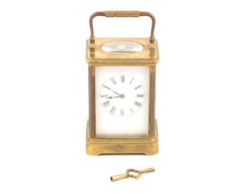 A French carriage style clock striking on the hour and half hour, white enamel dial with Roman numeral chapter ring, oval bev