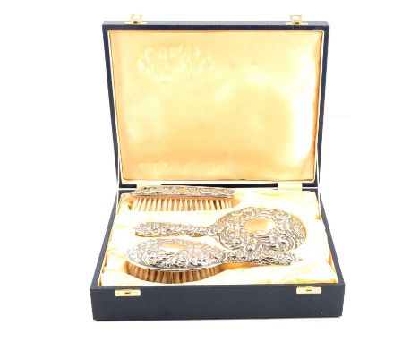 Silver three piece dressing table set, B&amp;Co., Birmingham 1992, embossed, comprising two brushes and a hand mirror, cased,