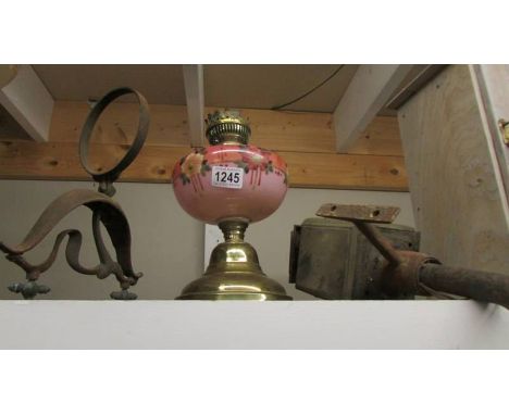 A Victorian oil lamp with pink glass font, a coach/porch lamp and a wall bracket.
