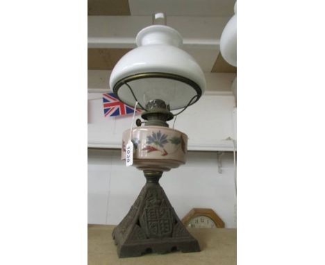 An old oil lamp on cast base with hand painted glass font and opaque glass shade, COLLECT ONLY.